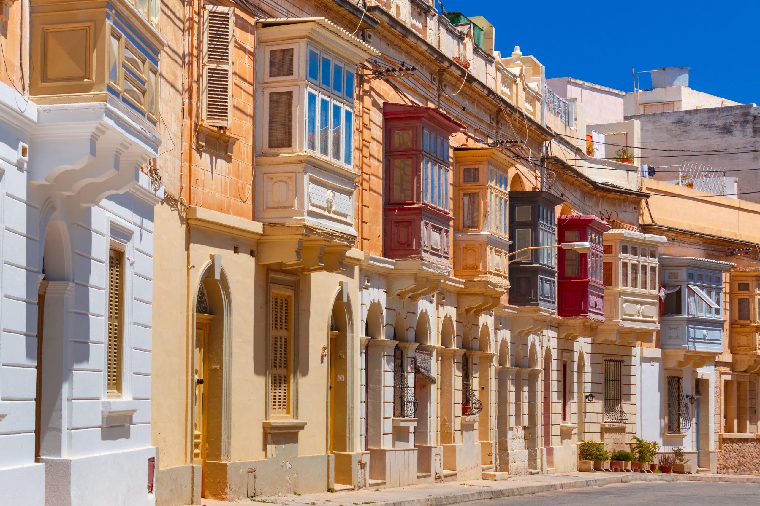 Traditional Maltese townhouses with colourful balconies, reflecting Malta’s architectural heritage and Victor Estate’s 60 years in the property industry.